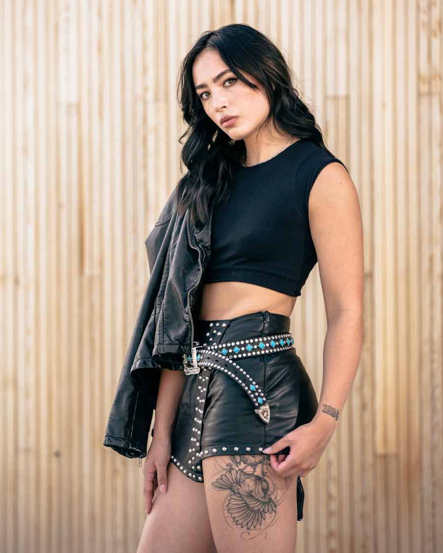 white female model with dark hair and tattoo on her thigh wearing leather