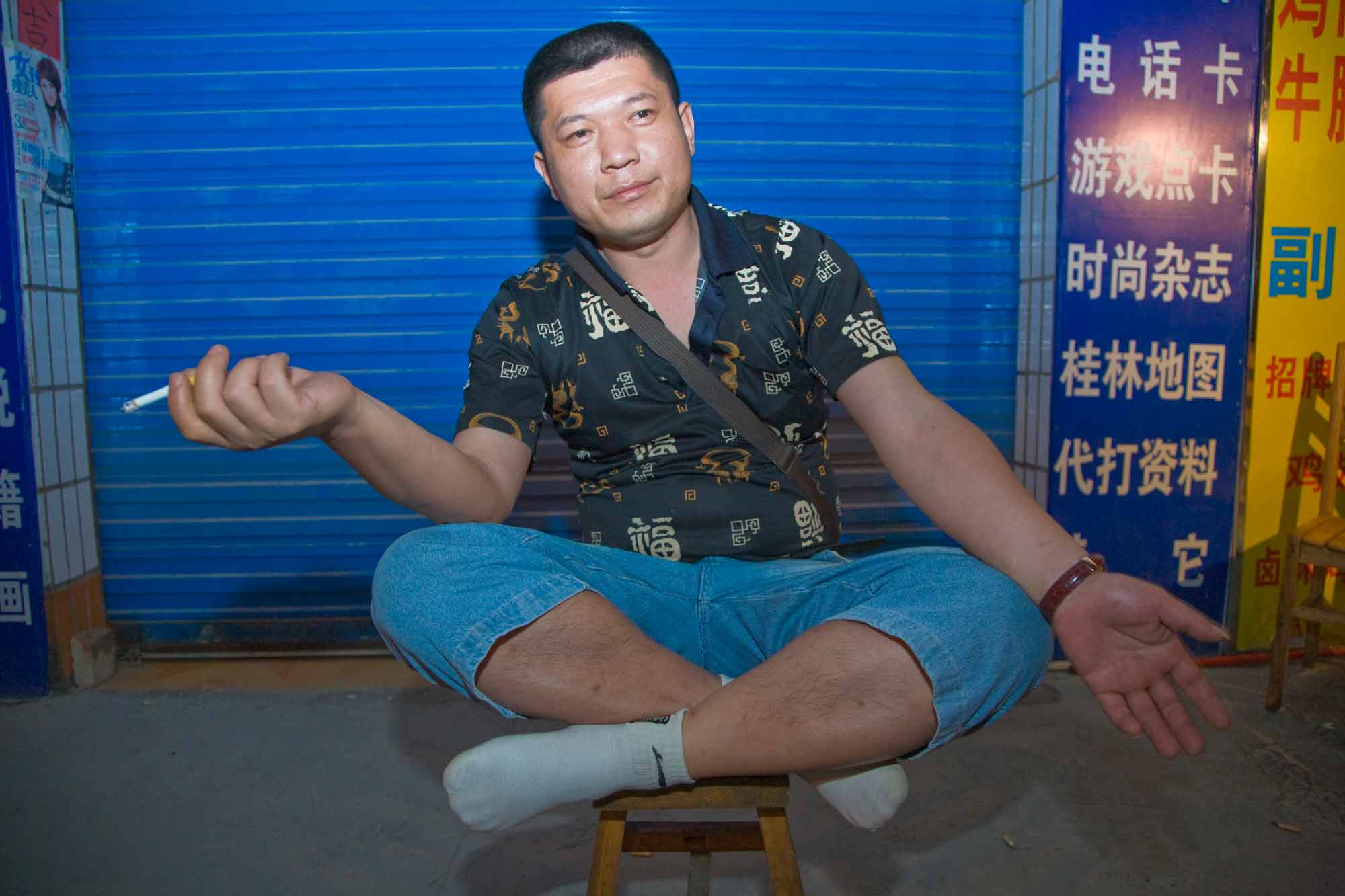 a chinese man in guilin sitting in a fun playful pose